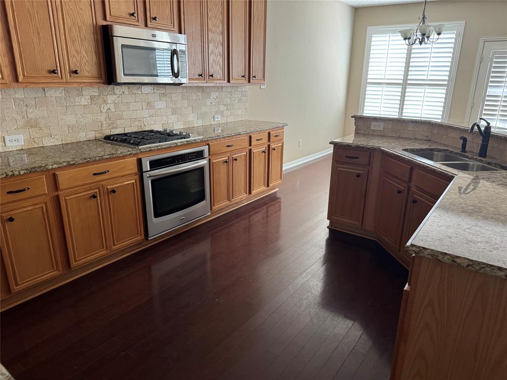 8272 Beartooth Drive Frisco, TX 75036 - Photo 3 of 16 a kitchen with granite countertop wooden cabinets stainless steel appliances and a window