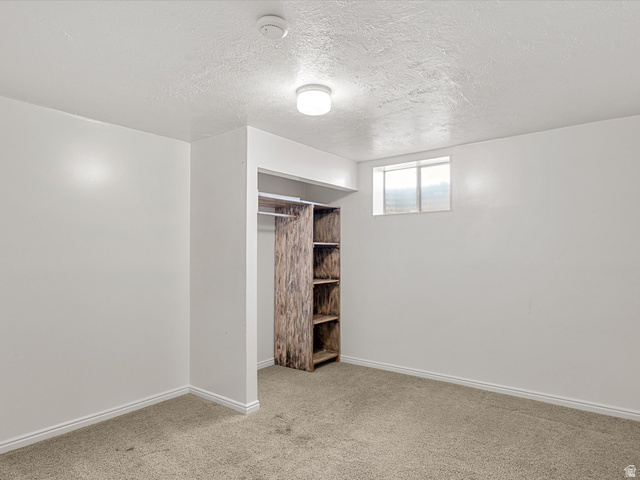 15680 North Beaver Dam Road Collinston, UT 84306 - Photo 32 of 49 Carpeted room featuring a built-in closet with shelving and hanging rod