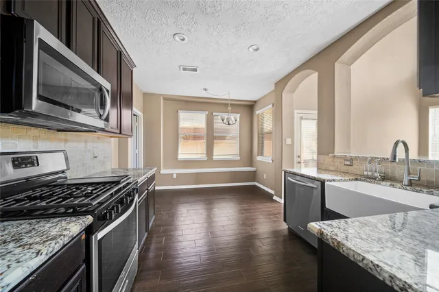 a kitchen with stainless steel appliances granite countertop a stove and a sink