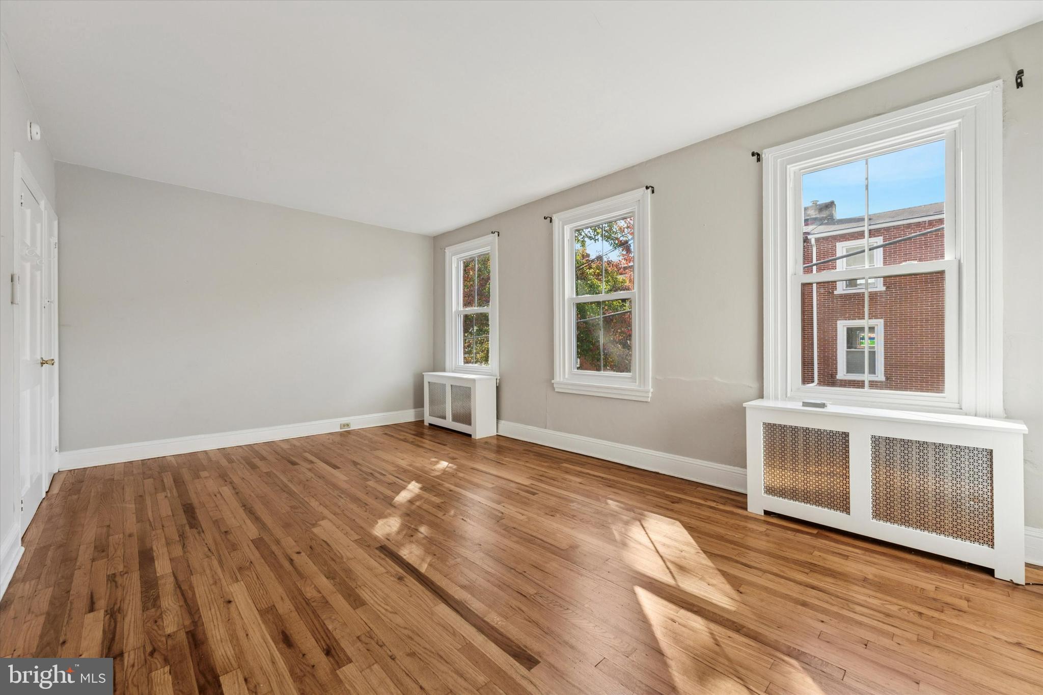 19 South New Street, Unit 2 West Chester, PA 19382 - Photo 16 of 20 a view of an empty room with wooden floor and a window