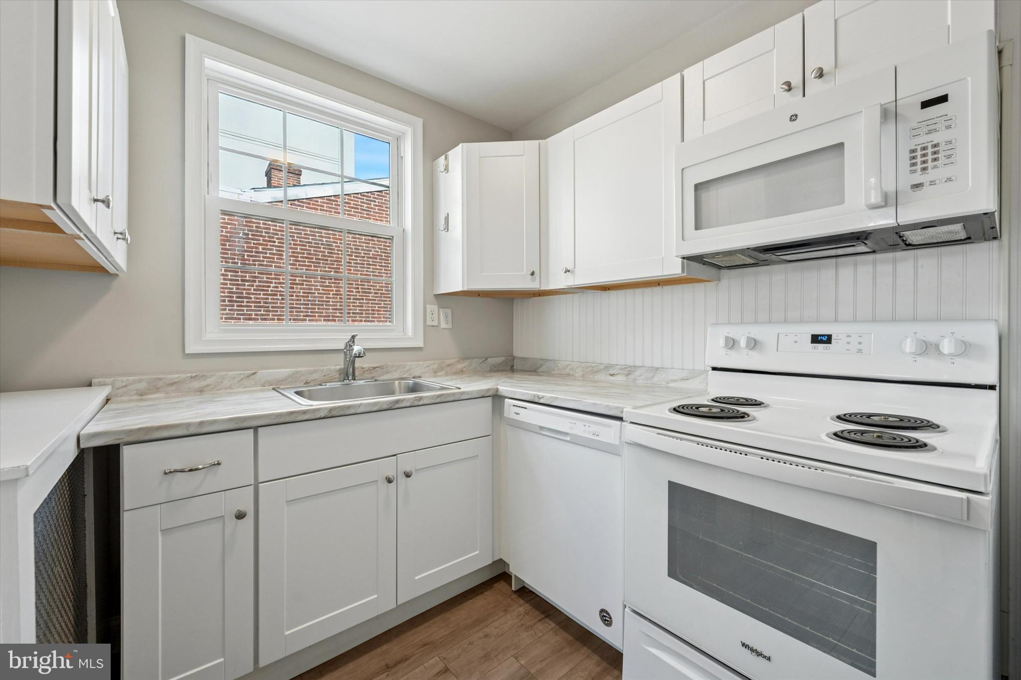 19 South New Street, Unit 2 West Chester, PA 19382 - Photo 10 of 20 a kitchen with granite countertop white cabinets and white appliances