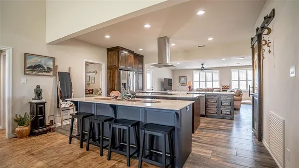 a kitchen with stainless steel appliances granite countertop a table chairs sink and cabinets