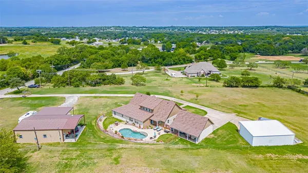an aerial view of a house with outdoor space swimming pool and mountains in the background