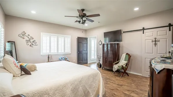 a bedroom with a bed a chair and a chandelier