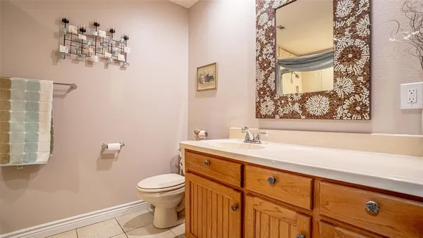 a bathroom with a granite countertop sink mirror vanity and toilet