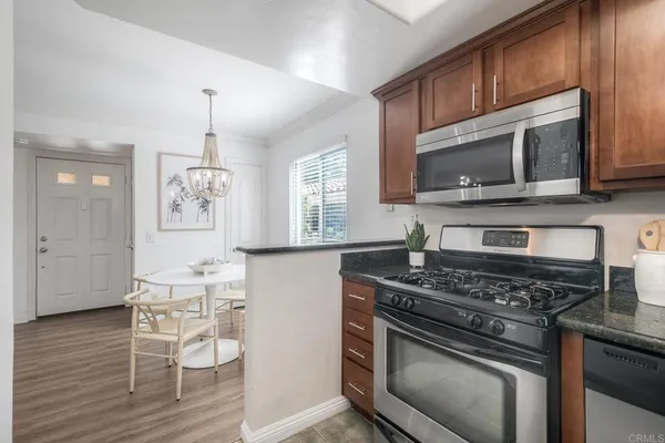 a kitchen with a stove a sink and wooden floor