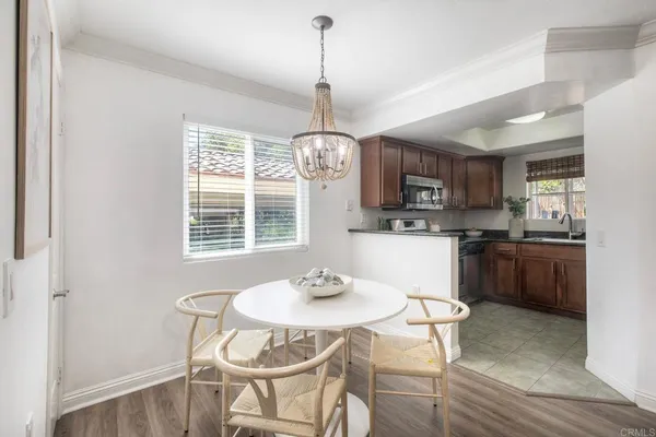 a kitchen with kitchen island granite countertop a sink a stove a dining table and chairs