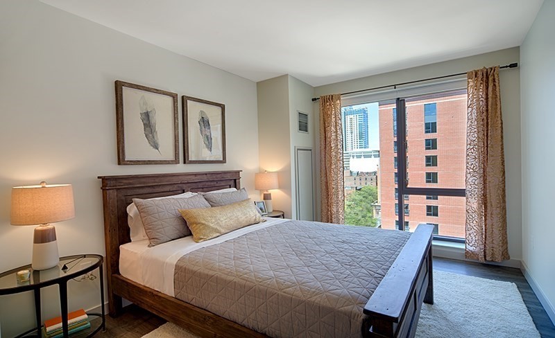 1 Canal Street, Unit 602 Boston, MA 02114 - Photo 4 of 12 a bedroom with a bed and a lamp on dresser