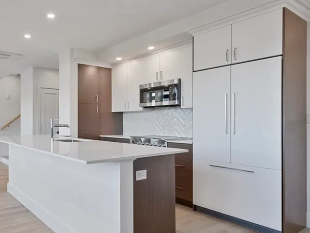 a kitchen with stainless steel appliances granite countertop a sink a refrigerator and a granite counter tops