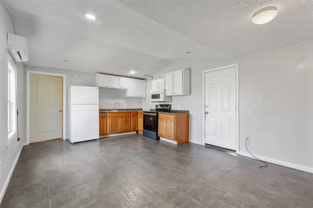 a view of kitchen with refrigerator cabinets and wooden floor