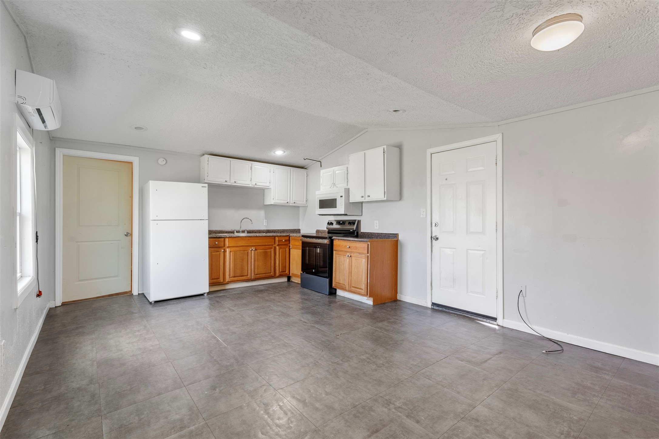 a view of kitchen with refrigerator cabinets and wooden floor