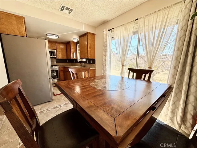 a view of kitchen island with stainless steel appliances granite countertop sink microwave and view of living room