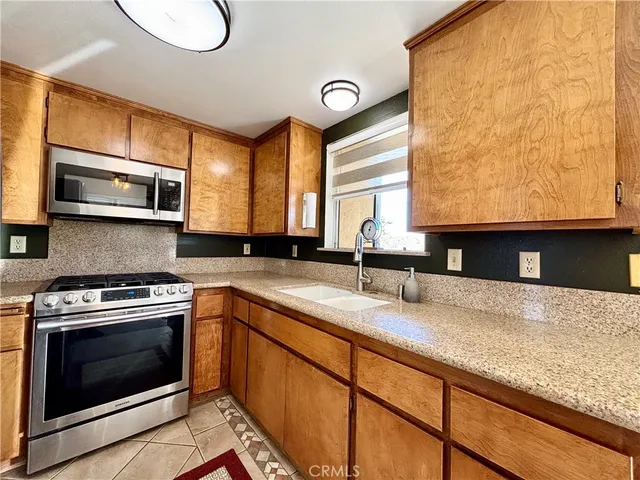 a kitchen with stainless steel appliances granite countertop a stove a sink and a microwave