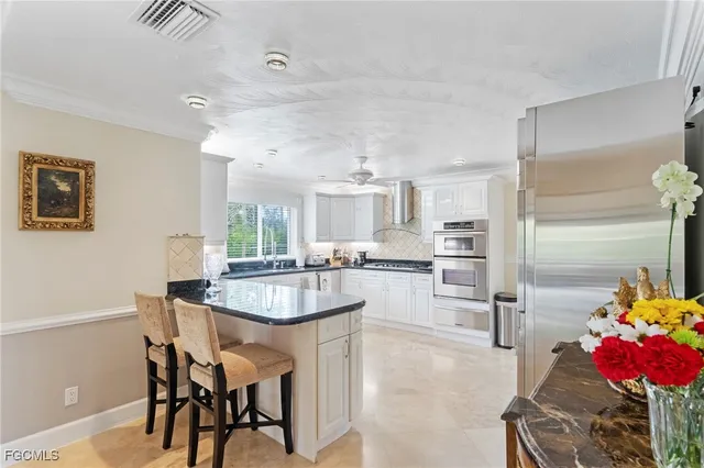 a dining room with furniture large windows and a potted plant