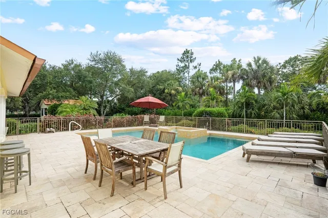 a view of a swimming pool with a table and chairs under an umbrella