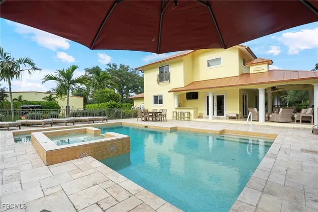 a view of a house with backyard sitting area and swimming pool