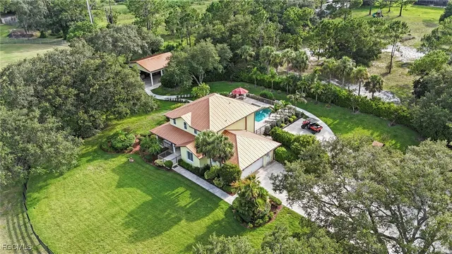 an aerial view of a house with a yard and outdoor seating