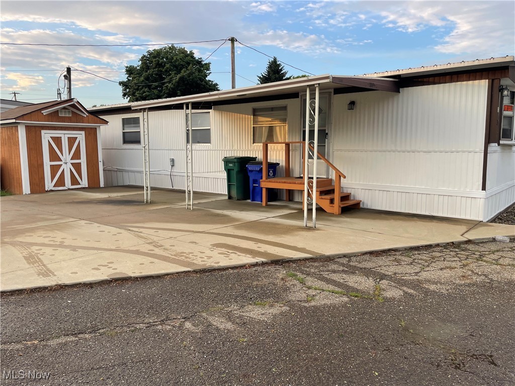 9329 Infirmary Road, Unit C13 Mantua, OH 44255 - Photo 1 of 9 View of front of house with a storage shed and a patio