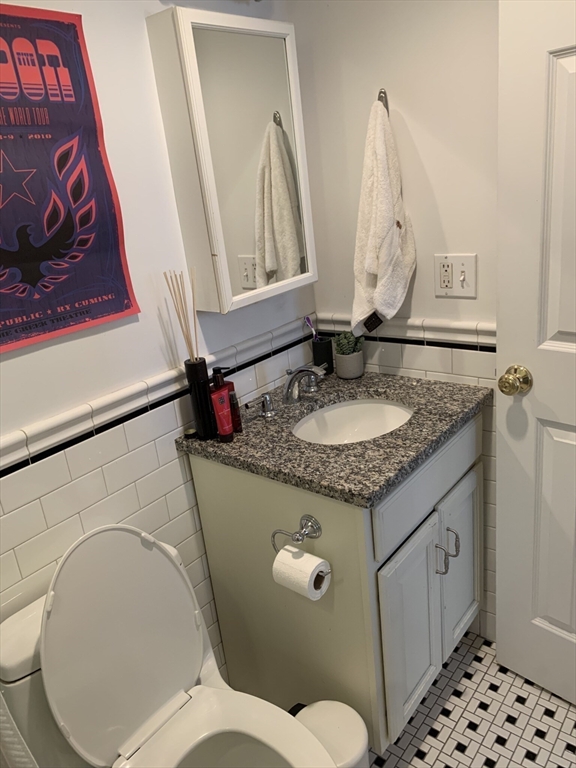 105 Pinckney Street, Unit 2 Boston, MA 02114 - Photo 11 of 13 a bathroom with a granite countertop toilet sink and mirror