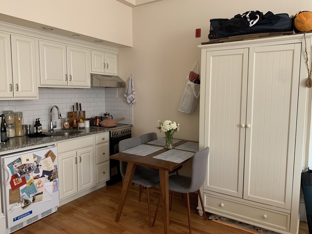 105 Pinckney Street, Unit 2 Boston, MA 02114 - Photo 2 of 13 a kitchen with stainless steel appliances granite countertop a refrigerator and sink