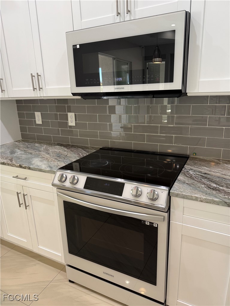 3013 4th Street West Lehigh Acres, FL 33971 - Photo 11 of 47 a stove top oven sitting inside of a kitchen