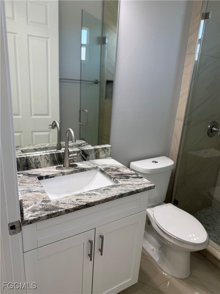 3013 4th Street West Lehigh Acres, FL 33971 - Photo 13 of 47 a bathroom with a granite countertop toilet sink and mirror