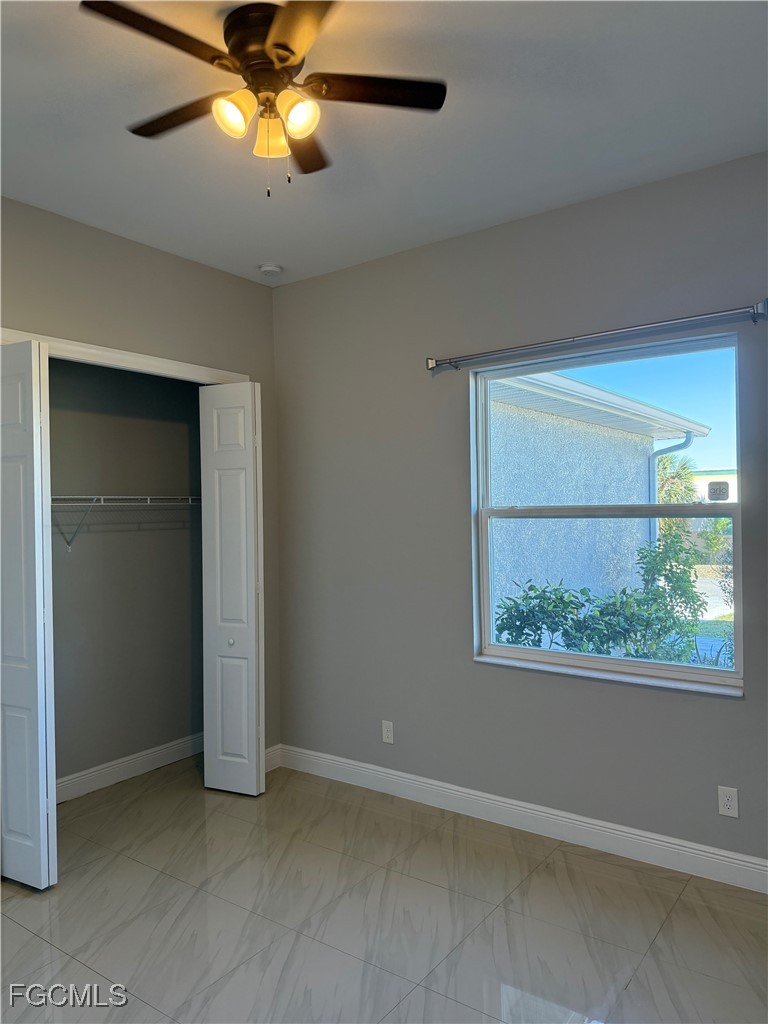 3013 4th Street West Lehigh Acres, FL 33971 - Photo 22 of 47 an empty room with a window and a fan