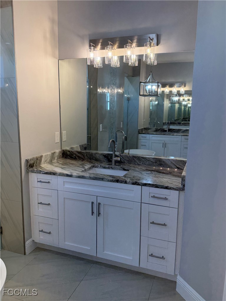 3013 4th Street West Lehigh Acres, FL 33971 - Photo 36 of 47 a bathroom with a sink and a large mirror