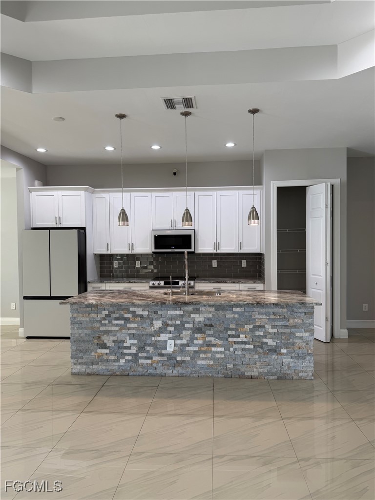 3013 4th Street West Lehigh Acres, FL 33971 - Photo 8 of 47 a large kitchen with kitchen island a sink stainless steel appliances and cabinets