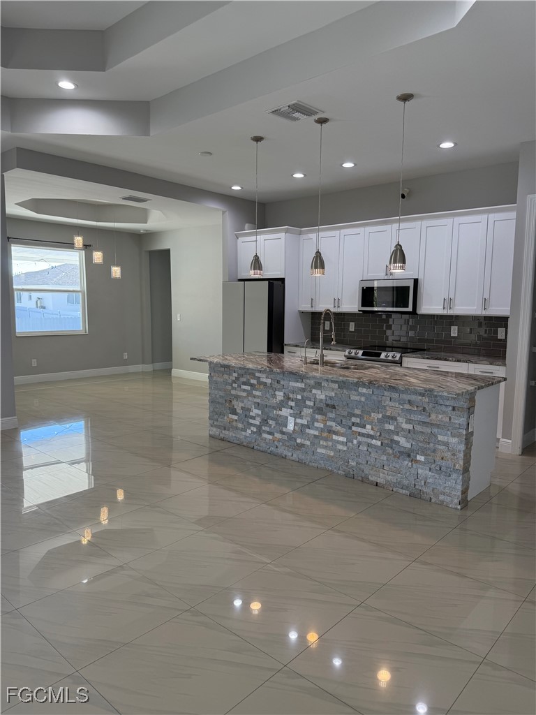 3013 4th Street West Lehigh Acres, FL 33971 - Photo 9 of 47 a large kitchen with kitchen island a sink stainless steel appliances and cabinets