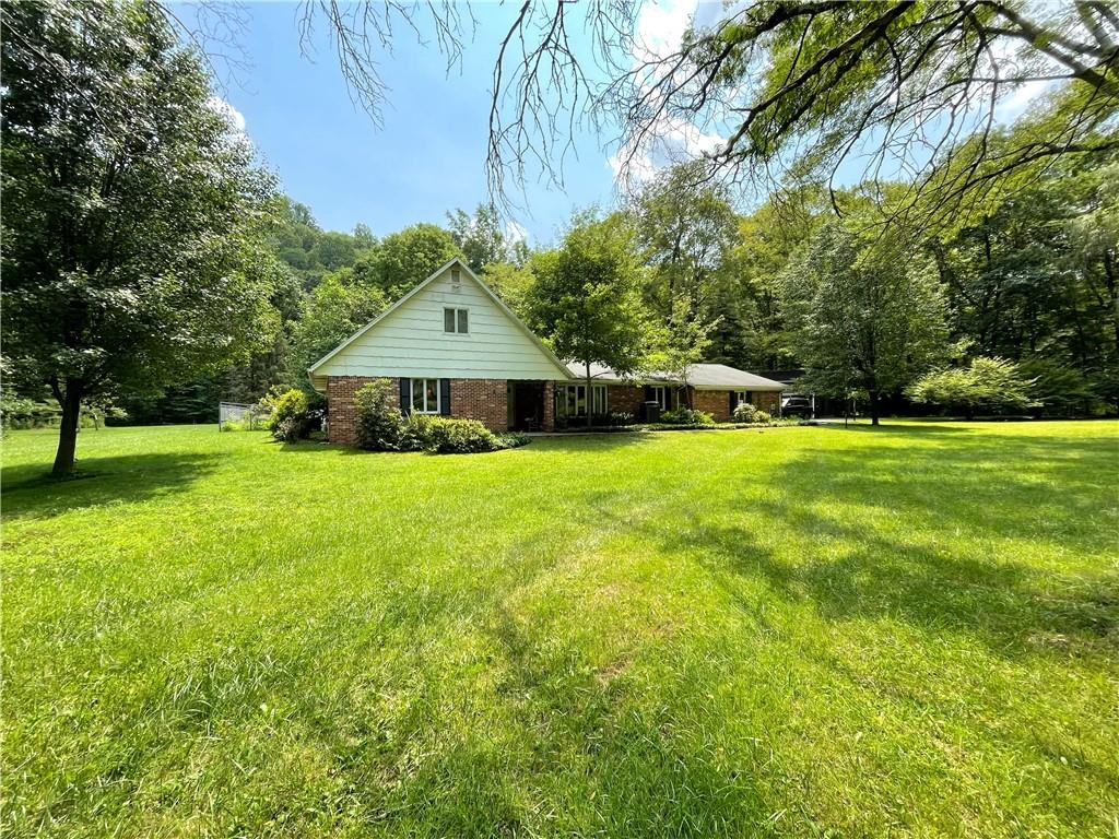 740 Four Mile Run Road Ligonier, PA 15658 - Photo 1 of 12 a view of a house with a garden and trees