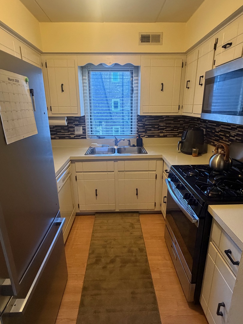 18135 Martin Avenue, Unit 2SW Homewood, IL 60430 - Photo 8 of 18 a kitchen with stainless steel appliances granite countertop a stove and a refrigerator