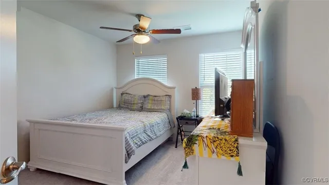 an empty room with a chandelier fan and windows