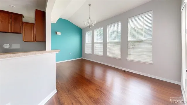 a view of a a dining room with furniture window and wooden floor