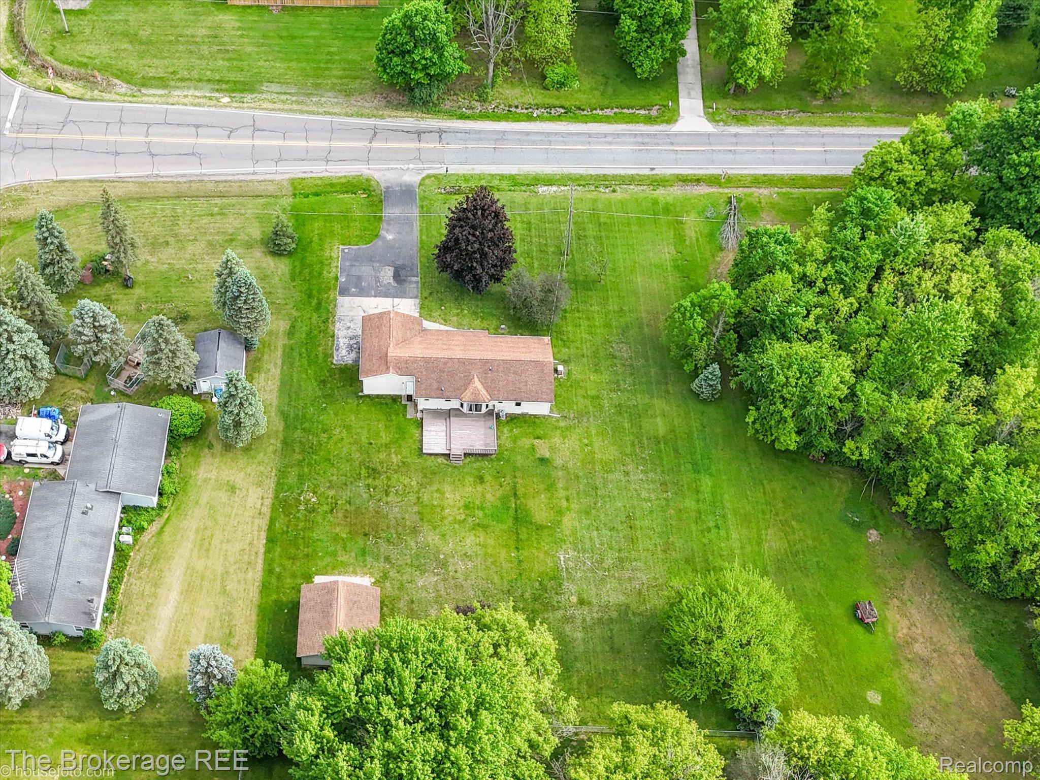5495 East Coldwater Road Flint, MI 48506 - Photo 6 of 44 Expansive lot featuring a main residence with a brown shingle roof, a paved driveway, and established perimeter trees