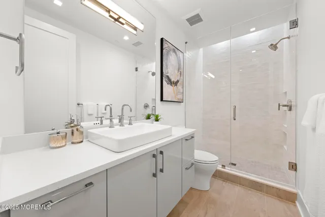 a bathroom with a sink a toilet and shower