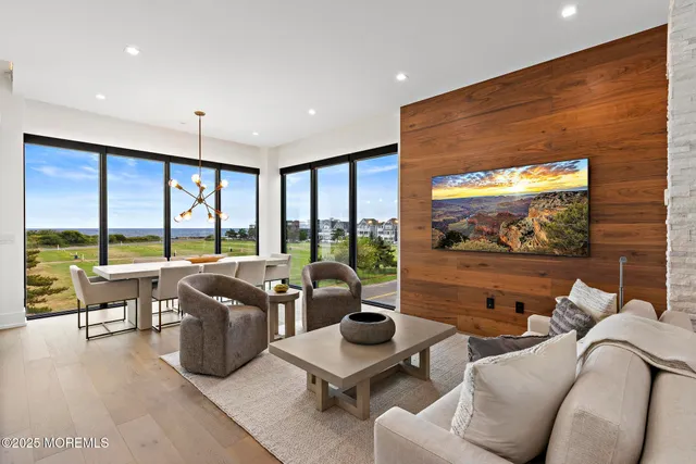 a living room with furniture tv and large windows