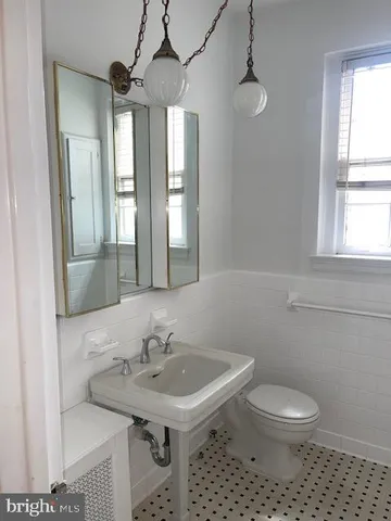 a bathroom with a sink a toilet and a mirror