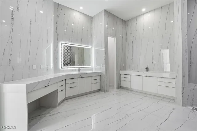 a large white bathroom with a large tub sink and vanity