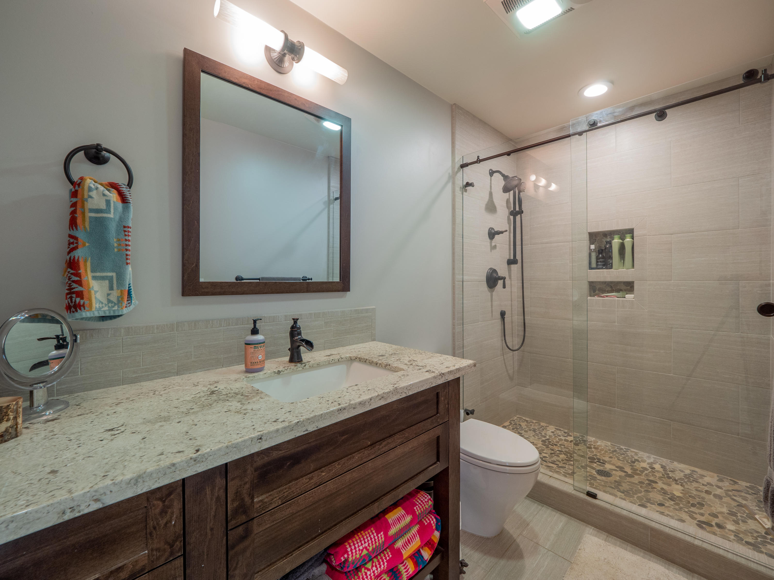 37600 Vedder Road Burney, CA 96013 - Photo 29 of 69 a bathroom with a granite countertop sink a toilet a mirror and shower