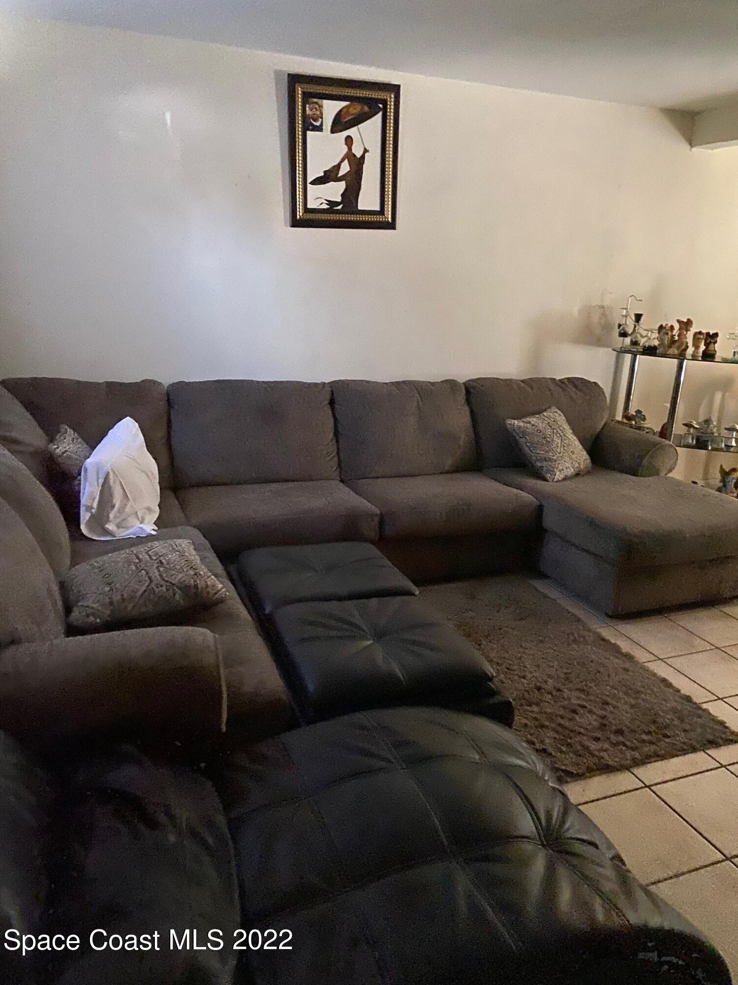19 Ella Street, Unit D Melbourne, FL 32935 - Photo 2 of 4 a living room with furniture and painting on the wall