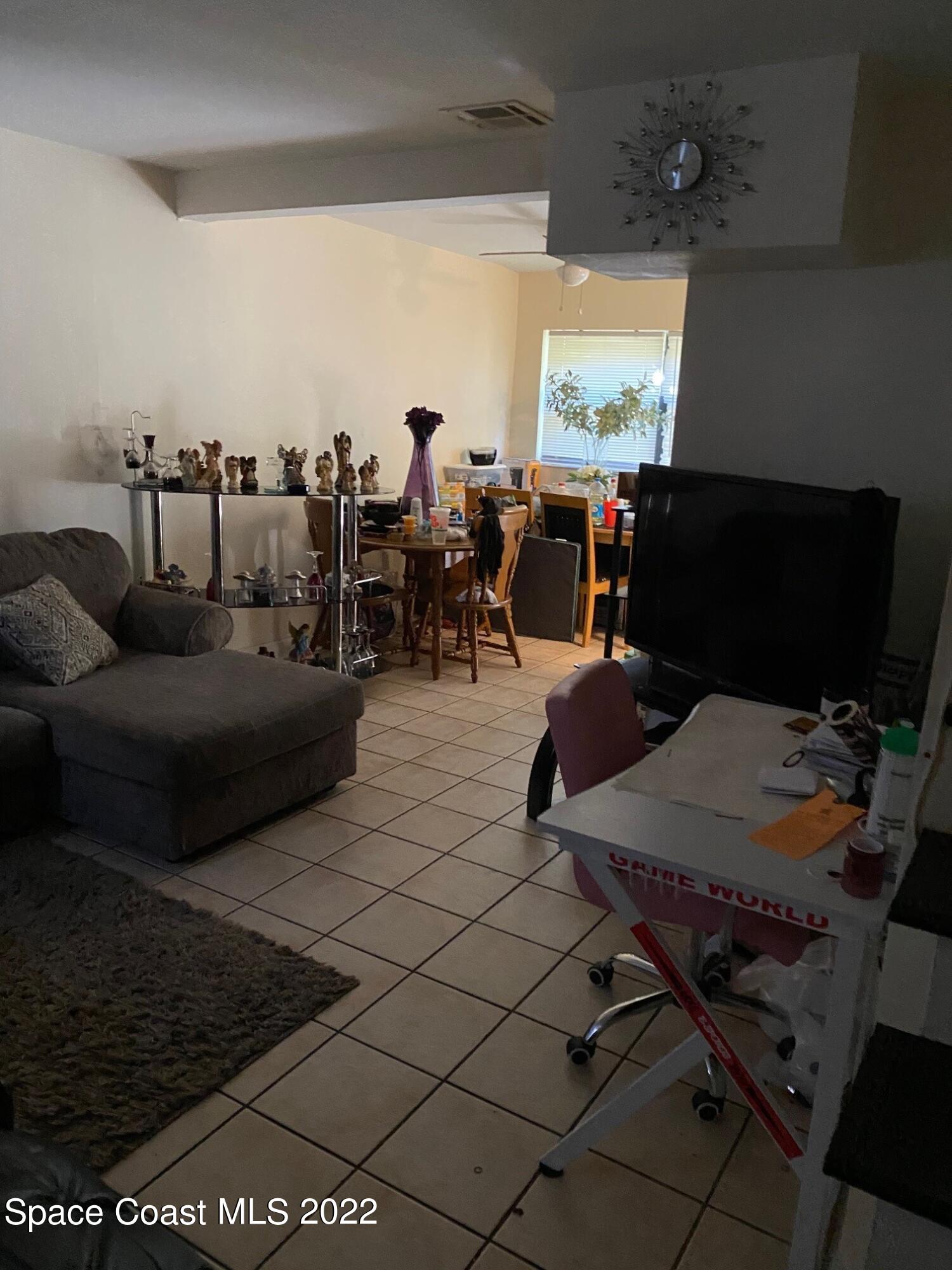 19 Ella Street, Unit D Melbourne, FL 32935 - Photo 3 of 4 a living room with furniture and a flat screen tv