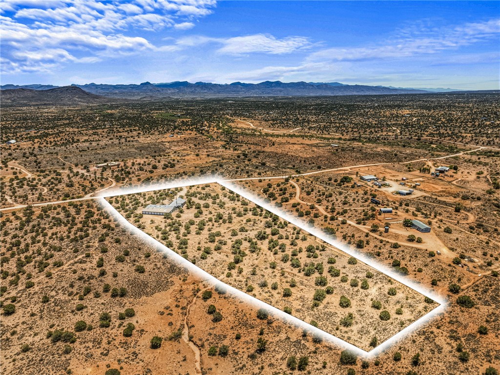 2401 North Stephan Road Kingman, AZ 86401 - Photo 87 of 92 Expansive desert property featuring a modern structure, multiple outbuildings, and a surrounding landscape of arid vegetation