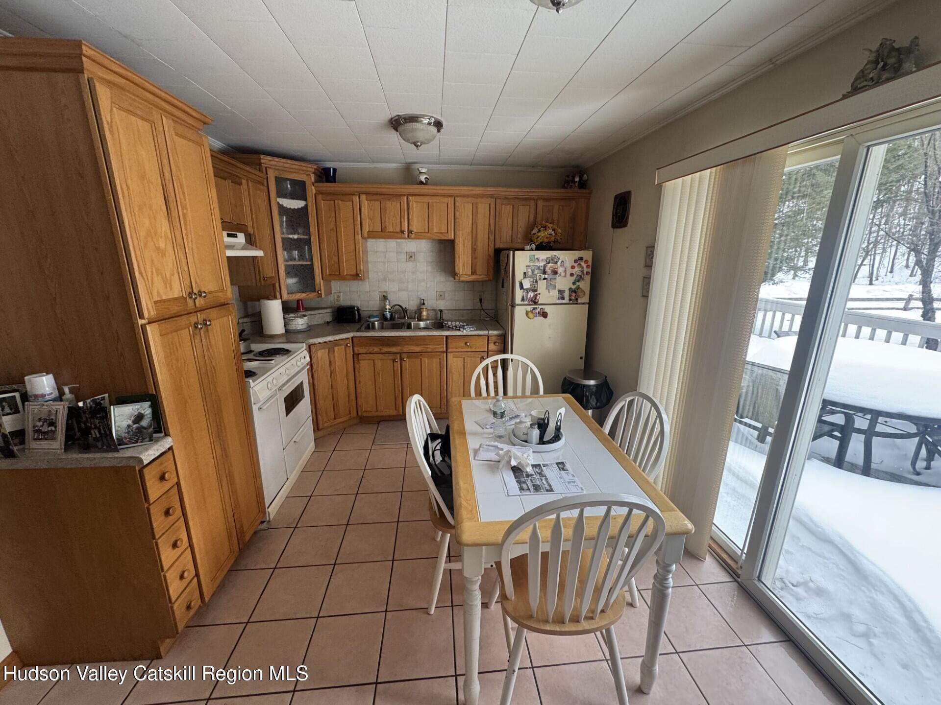 107 Route 40 Road Hensonville, NY 12439 - Photo 9 of 22 a kitchen with stainless steel appliances a refrigerator a sink a stove a dining table and chairs