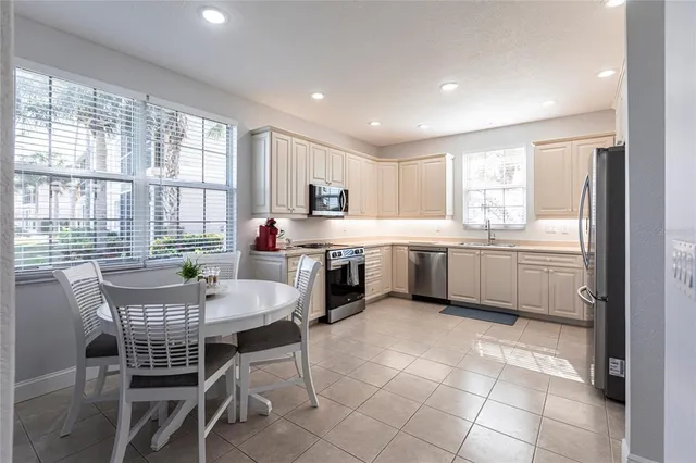 a kitchen with a table chairs sink and cabinets