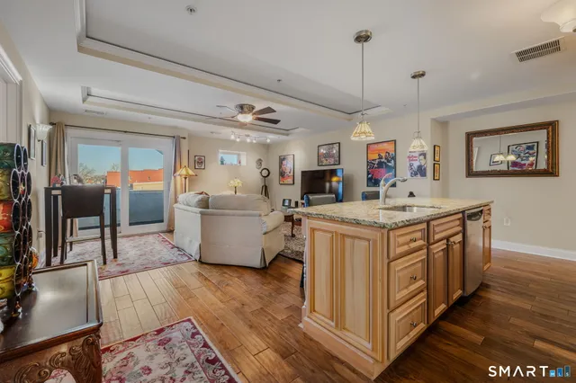 a kitchen with stainless steel appliances granite countertop a sink stove and wooden floor