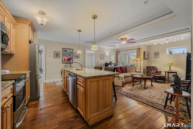 a large kitchen with stainless steel appliances granite countertop a lot of counter space and wooden floors