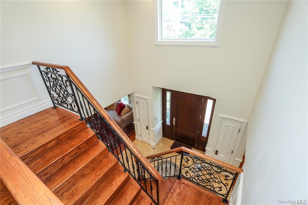 24 Steamboat Road Great Neck, NY 11024 - Photo 16 of 28 Entryway featuring stairs, wood finished floors, a decorative wall, and a wainscoted wall