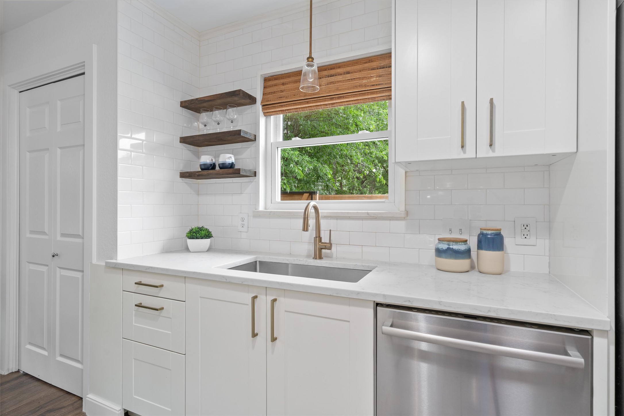 8436 Bangor Bend Austin, TX 78758 - Photo 13 of 29 Floating wood shelves and a leafy window view add just the right amount of warmth to the kitchen.
