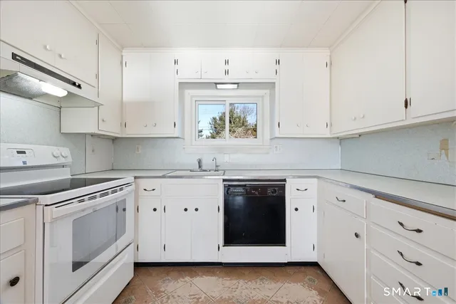 a kitchen with white cabinets and white appliances